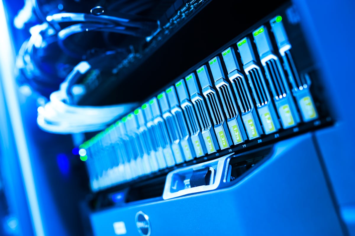 A blue-lit rack of enterprise servers with green status LEDs
