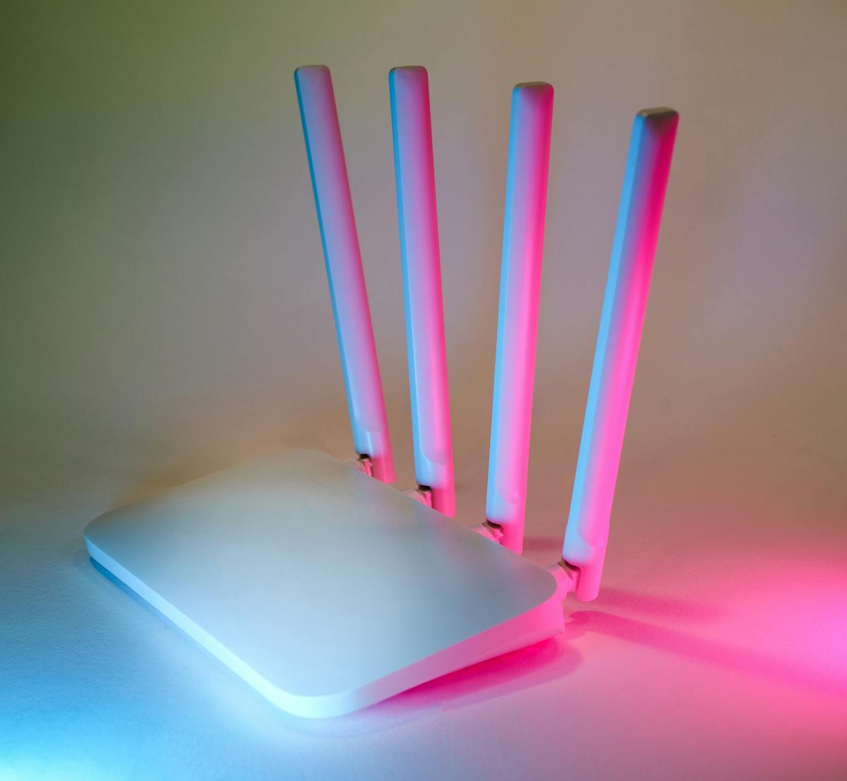 A sleek wireless router with antennas illuminated by neon lighting