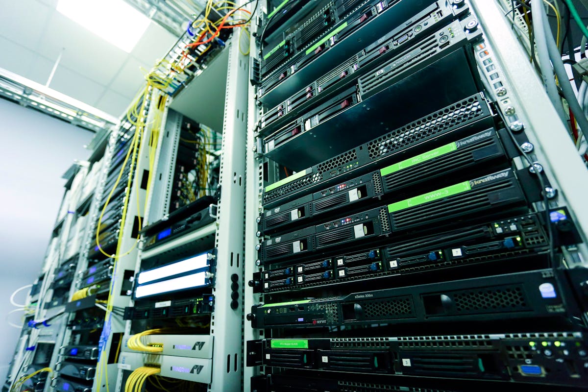 A rack of network servers with yellow and green patch cables