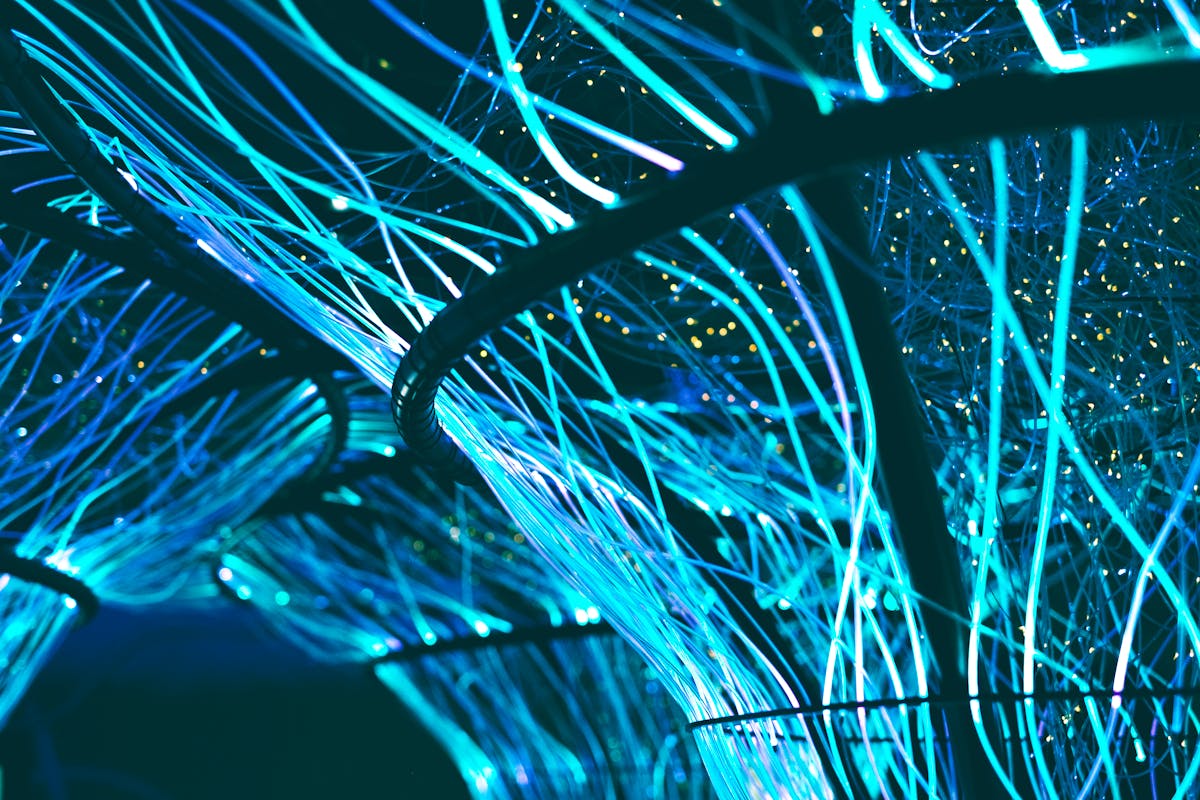 Glowing cyan fiber optic strands carrying data