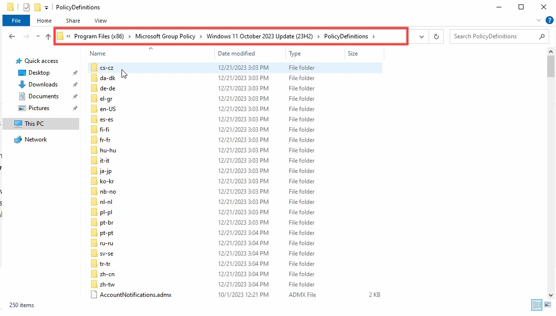 File Explorer at C colon backslash Program Files (x86) backslash Microsoft Group Policy backslash Windows 11 October 2023 Update backslash PolicyDefinitions showing the extracted ADMX files alongside the en-US sub-folder containing the matching ADML language files